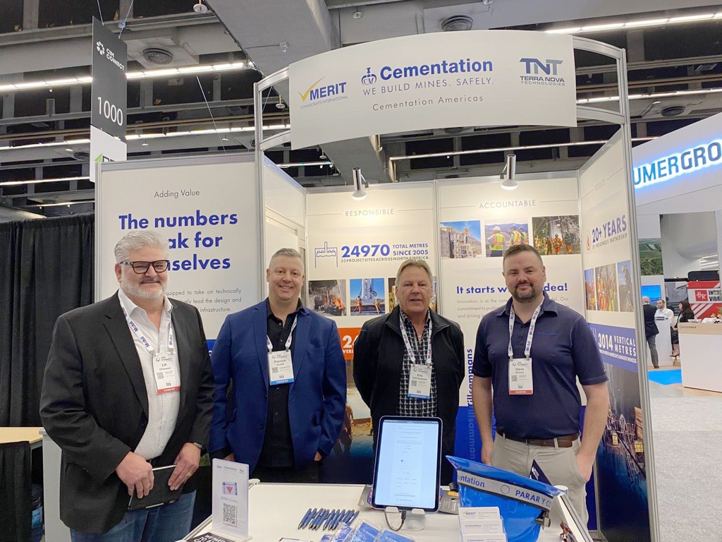 Four men standing in front of a tradeshow booth.